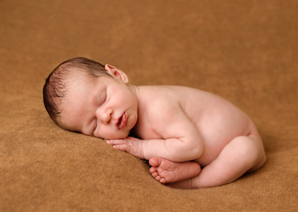 Newborn baby peacefully posed with utmost care, highlighting delicate features and gentle support for a safe and cozy photography session in Summerside.